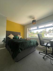 a bedroom with a bed and a desk and a chair at White House Villa in Nottingham