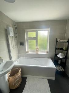 a white bathroom with a tub and a sink at White House Villa in Nottingham