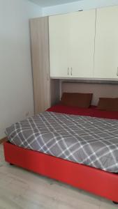 Cama roja en habitación con armarios blancos en Villa Simon en Lamezia Terme