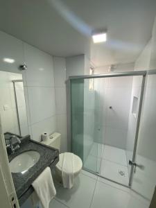 a bathroom with a shower and a toilet and a sink at Veleiro Praia Hotel in Maceió