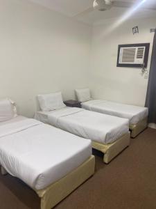 3 lits sont disposés dans une pièce dans l'établissement عمارة درة السلطان, à Ash Shishah