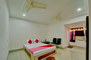een witte kamer met een bed en een raam bij Super OYO Flagship Hotel Shakti Inn in Jamshedpur
