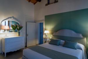 Schlafzimmer mit einem Bett, einer Kommode und einem Spiegel in der Unterkunft Dimo' Rè in Farnese