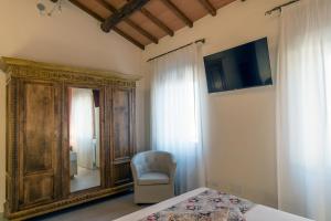 a bedroom with a bed and a chair and a mirror at Dimo' Rè in Farnese