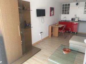 ein kleines Wohnzimmer mit einer Küche und einem Tisch in der Unterkunft Apartamento in Sanlúcar de Barrameda