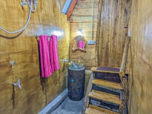 a bathroom with a wooden cabin with a bench and a barrel at Wooden Cabana Sigiriya in Sigiriya