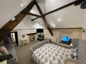 a bedroom with a bed and a couch in a room at Large Historic Farmhouse in Rhondda Valley Perfect for Groups with Hot Tub in Blaencwm