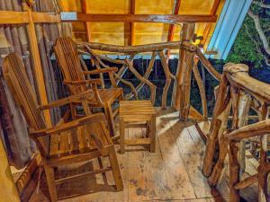 錫吉里亞的住宿－Wooden Cabana Sigiriya，门廊上的两把椅子和一张桌子