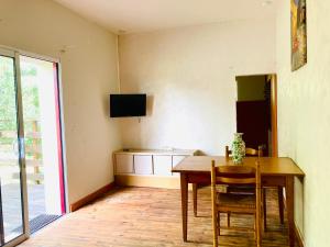 a dining room with a table and a television on the wall at Métairie de Moutiques in Cazaubon