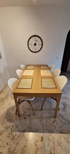 a wooden table with chairs and a clock on the wall at PUEBLO in Benalmádena