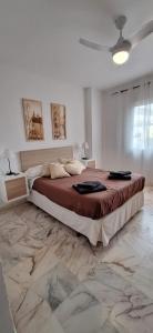 um quarto com uma cama grande num quarto branco em PUEBLO em Benalmádena