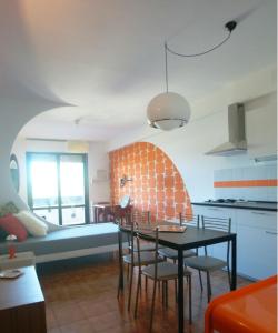 cocina y sala de estar con mesa y sillas en Appartamento Velocipede en Cervignano del Friuli