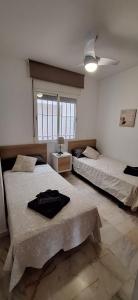 um quarto com 2 camas e uma janela em PUEBLO em Benalmádena