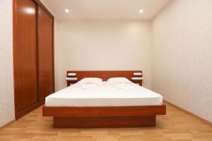 um pequeno quarto com uma cama com lençóis brancos em AM Apartments 5 em Yerevan