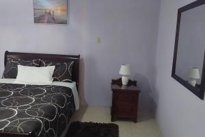 1 dormitorio con cama y mesa con espejo en MB's Chillspot en Saint Annʼs Bay