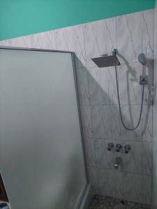 ein Bad mit einer Dusche mit einem Duschkopf in der Unterkunft MB's Chillspot in Saint Annʼs Bay