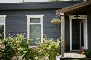 a gray house with a porch and a door at Ocean Breeze in Cork