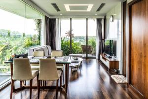 sala de estar con mesa, sillas y sofá en 1BR, 1 Sofa bed Luxurious 5-stars Flamingo Resort., en Phúc Yên