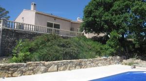 a house with a stone wall and a swimming pool at Les Hauts des Materonnes in Tourves