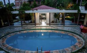 a large swimming pool in front of a house at Hotel Sanctuary Resort in Sawāi Mādhopur