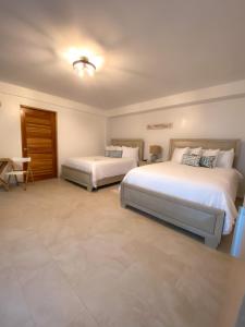 a bedroom with two beds and a table at Tres Palmas by La Cambija in Rincon