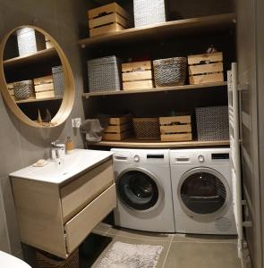 een wasruimte met een wasmachine en een wastafel bij Villa à Biarritz avec une terrasse un SPA et parking in Biarritz