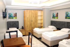 a room with two beds and a table and a dining room at Avist Hotel Avcılar in Avcılar