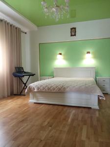 a bedroom with a white bed and a green wall at MODEST in Slavske