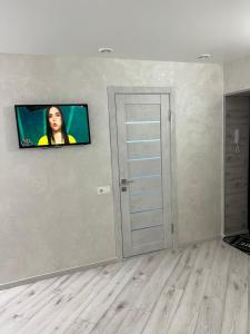 Pokój z telewizorem z płaskim ekranem na ścianie w obiekcie бул. Шевченка 352, квартира-студія w Czerkasach
