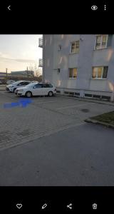 due auto parcheggiate in un parcheggio di fronte a un edificio di Leaf House a Sibiu