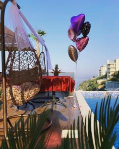 a patio with a table and balloons next to a pool at Apart Lux Beciragic in Dobra Voda