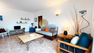 a living room with a blue couch and a table at Albufeira Calipto by Sunny Deluxe in Albufeira