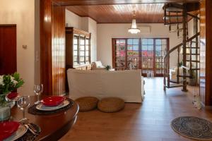 a living room with a table and chairs and windows at ELMAR ARTemida in Artemida