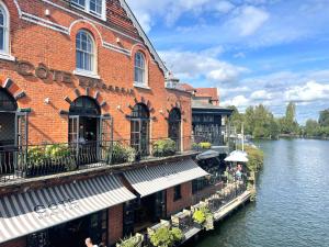 a large brick building next to a river at Cosy Eton Escape with parking. in Eton