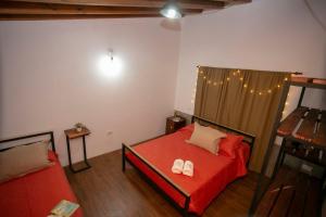 1 dormitorio con cama roja y sofá en CABAÑAS EL CAMINO en San Luis