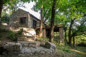 un edificio de piedra con un banco en el bosque en CABAÑAS EL CAMINO en San Luis