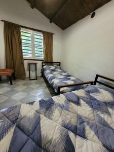 a bedroom with two beds and a table and window at CABAÑAS EL CAMINO in San Luis