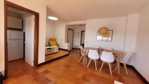 a dining room with a table and white chairs at Casa Amarela _ Sesimbra in Sesimbra
