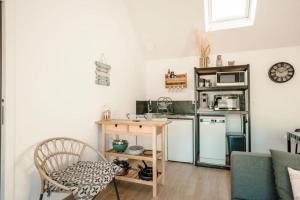 a small kitchen with a table and a microwave at Loft du Pain avec SPA privatif in Druye