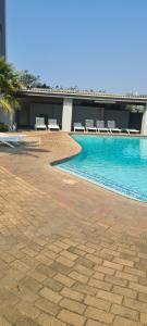 a swimming pool with lounge chairs in a building at Santana holiday resort 803 in Margate