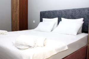 uma cama com lençóis brancos e toalhas em Avist Hotel Avcılar em Avcılar