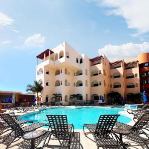 a resort with a swimming pool with chairs and a building at Sea of Cortez Beach Club in San Carlos