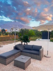 a blue couch and an umbrella in a yard at LA COSTA DI SAN GIORGIO in Agios Georgios