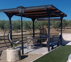 a gazebo with a table and chairs under it at Casa la limosna in Setenil