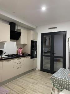 a kitchen with white cabinets and a black door at Lux appartment khezama sousse in Sousse
