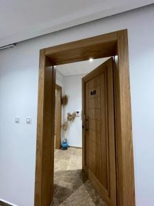 a hallway with a wooden door in a room at Lux appartment khezama sousse in Sousse