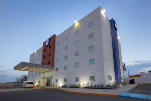 a white hotel with a sign on the side of it at Sleep Inn Mexicali in Mexicali