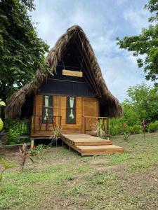 a small cabin with a thatched roof at Ecohab -Parque Tayrona in Santa Marta
