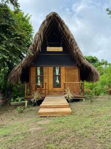 Cabaña pequeña con techo de paja y escalera de madera en Ecohab -Parque Tayrona, en Santa Marta