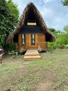 a small cabin with a thatched roof at Ecohab -Parque Tayrona in Santa Marta